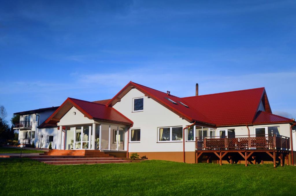 ein großes weißes Haus mit rotem Dach in der Unterkunft Zielona Dolina in Nowogródek Pomorski