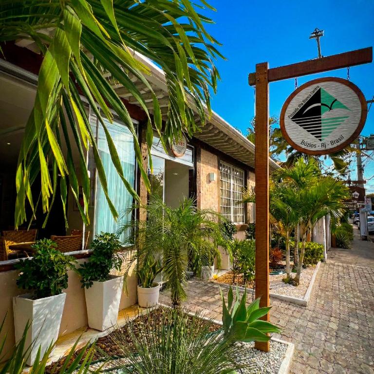 a sign in front of a building with plants at Pousada Ilha Branca Centro in Búzios