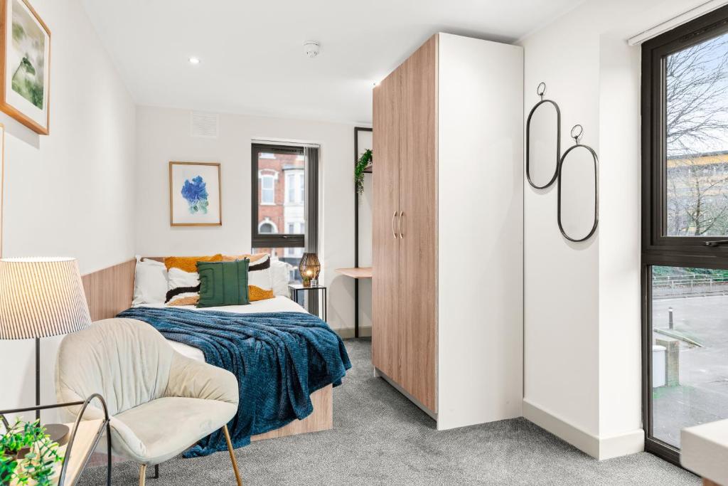 a bedroom with a bed and a chair at Stylish Studio Apartment with Free Parking in Wolverhampton 5min walk to City Centre in Wolverhampton