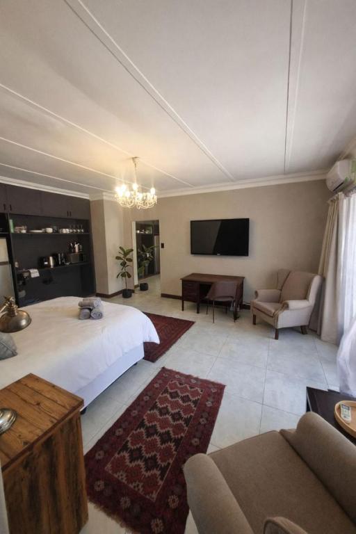 a large bedroom with a bed and a tv at River Suite at On-the-Up in Potchefstroom