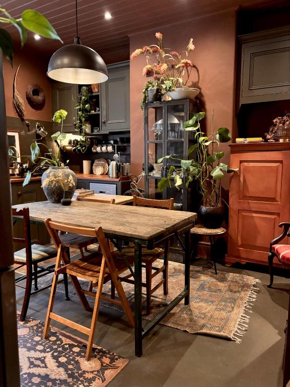 a dining room with a table and some plants at The Goose Garden in Hebden Bridge