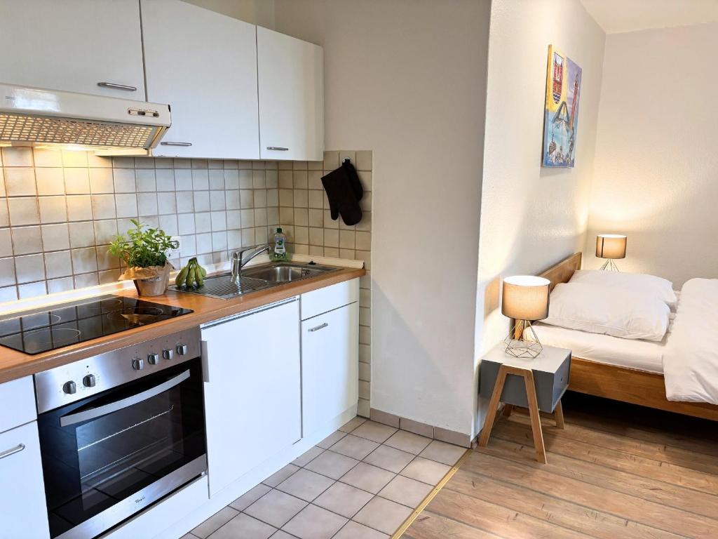 a small kitchen with a sink and a bed at Jutta vom Kutter in Wulfen auf Fehmarn