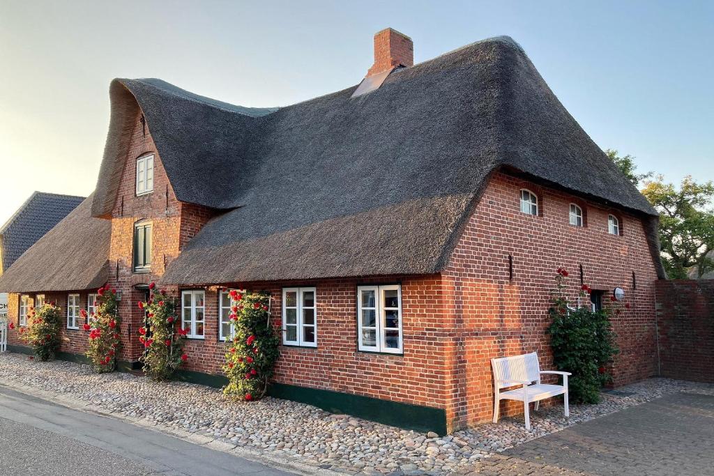 a red brick house with a black roof at Haus 25 in Oldsum in Oldsum