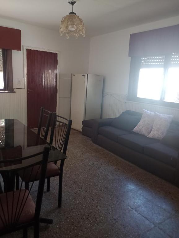 a bedroom with a bed and a table and a desk at La casita lila in Mar de Ajó