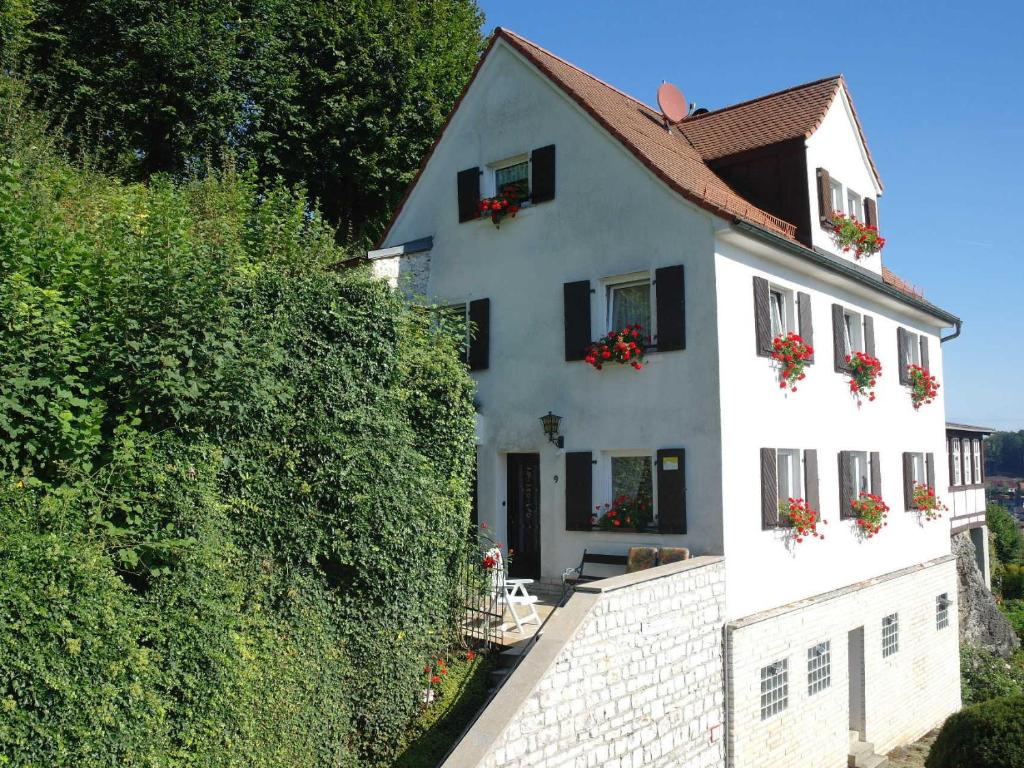 a white house with flower boxes on the windows at Ferienwohnung Haus Wagnershoehe in Gößweinstein