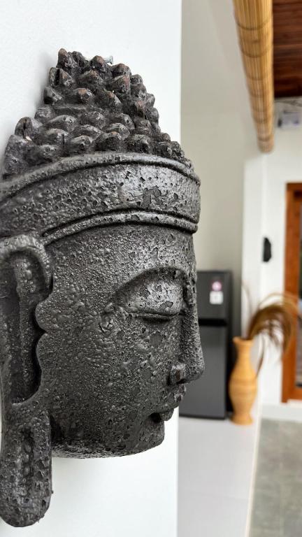 a statue of a head hanging on a wall at Peony Villa Lovina in Lovina