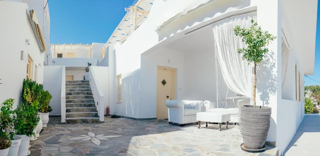 a white house with a staircase and a stair case at The White Suites in Adamas