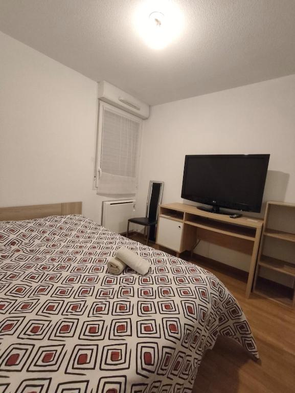 a bedroom with a bed and a flat screen tv at nice apartment strategic location in Muret