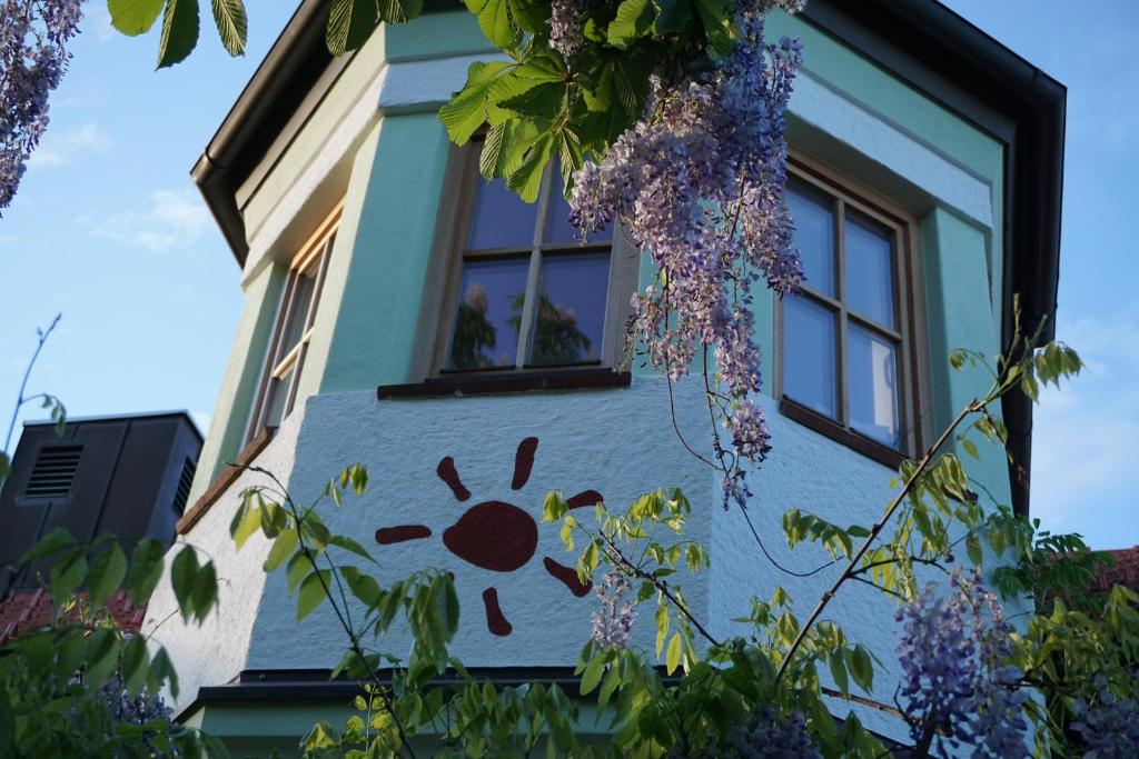 a building with a flower painted on the side of it at Weissenfelder Guest House & Restaurant in Weißenfeld