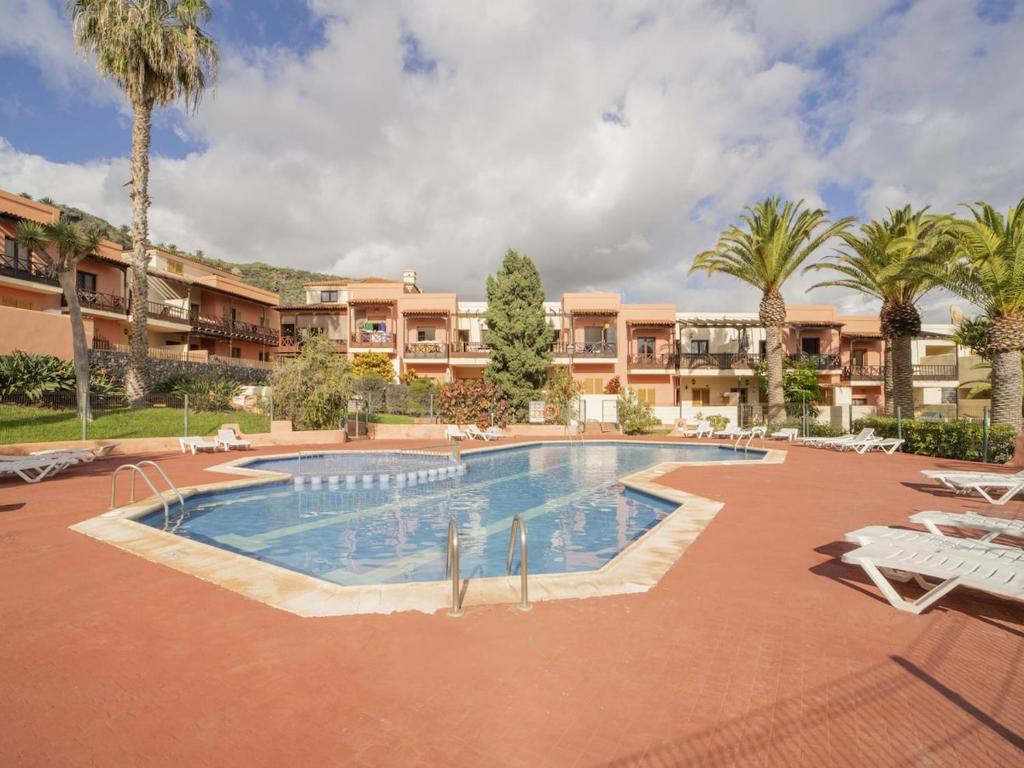 a large swimming pool in a resort with palm trees at CHL La Mareta, cozy apartment with pool in Breña Baja