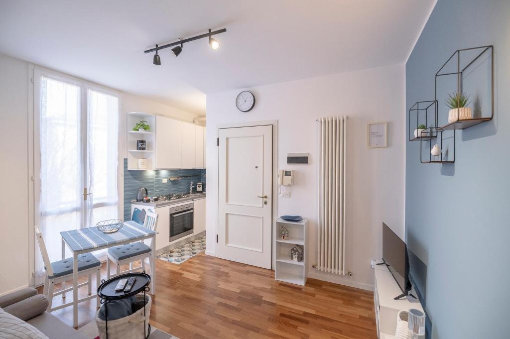 a living room with a table and a clock on the wall at Vdoppia Apartment in San Giovanni in Persiceto