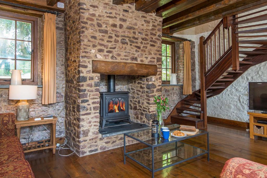 a fireplace in a living room with a brick wall at Coach House in Pembroke
