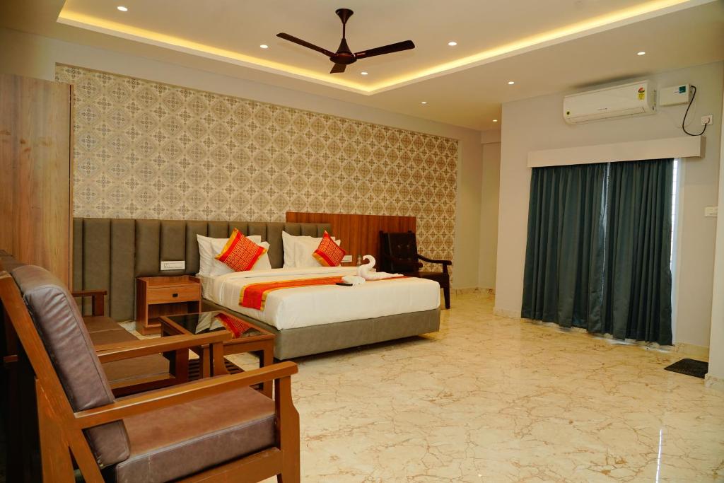 a bedroom with a bed and a chair in a room at AAryavarth suites 46 in Pālasmudram