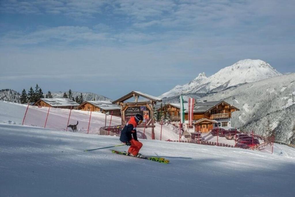 a person is skiing down a snow covered slope at Chalet Torstein in Schladming