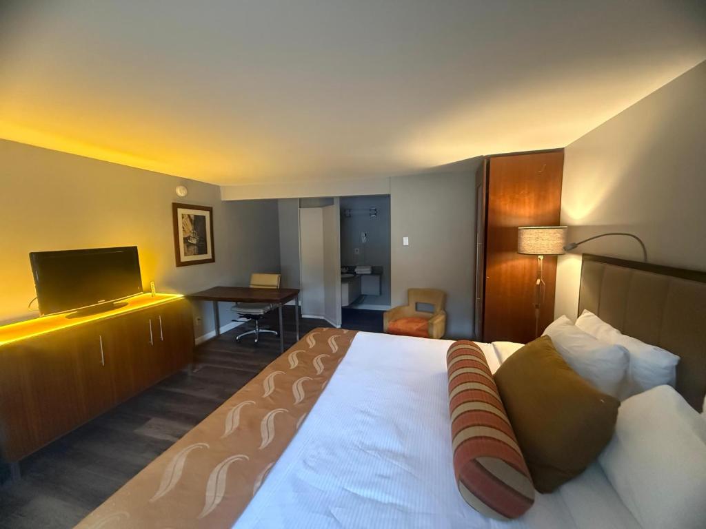 a hotel room with a large bed and a desk at Naval Suites by FairBridge in Bremerton