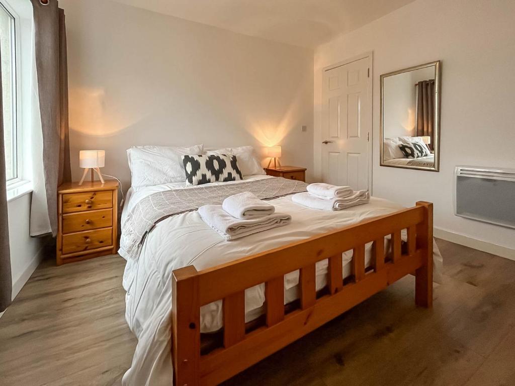 a bedroom with a large bed with towels on it at 6 Mill Road in Okehampton