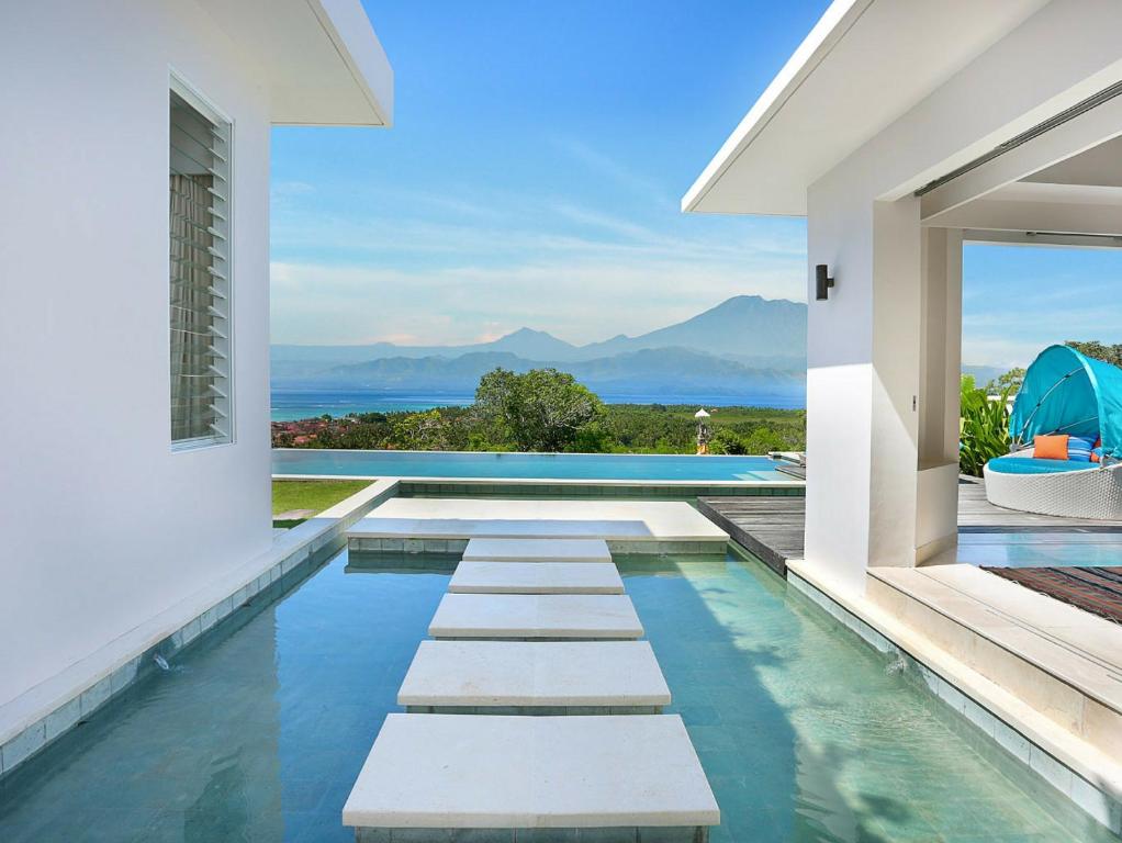 a house with a swimming pool with a view of the ocean at 353 Degrees North in Nusa Lembongan