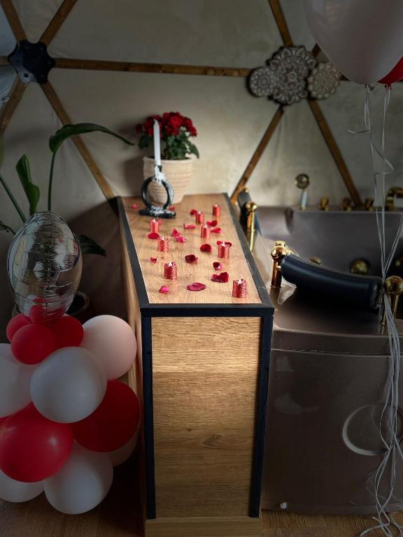 a table with red candles on top of it with balloons at Ghadi Domes in Nimrod