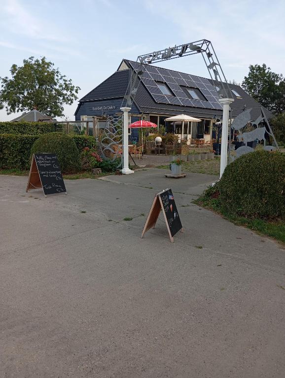 two signs on the ground in front of a building at Boerderij De Diek'n in Zeerijp