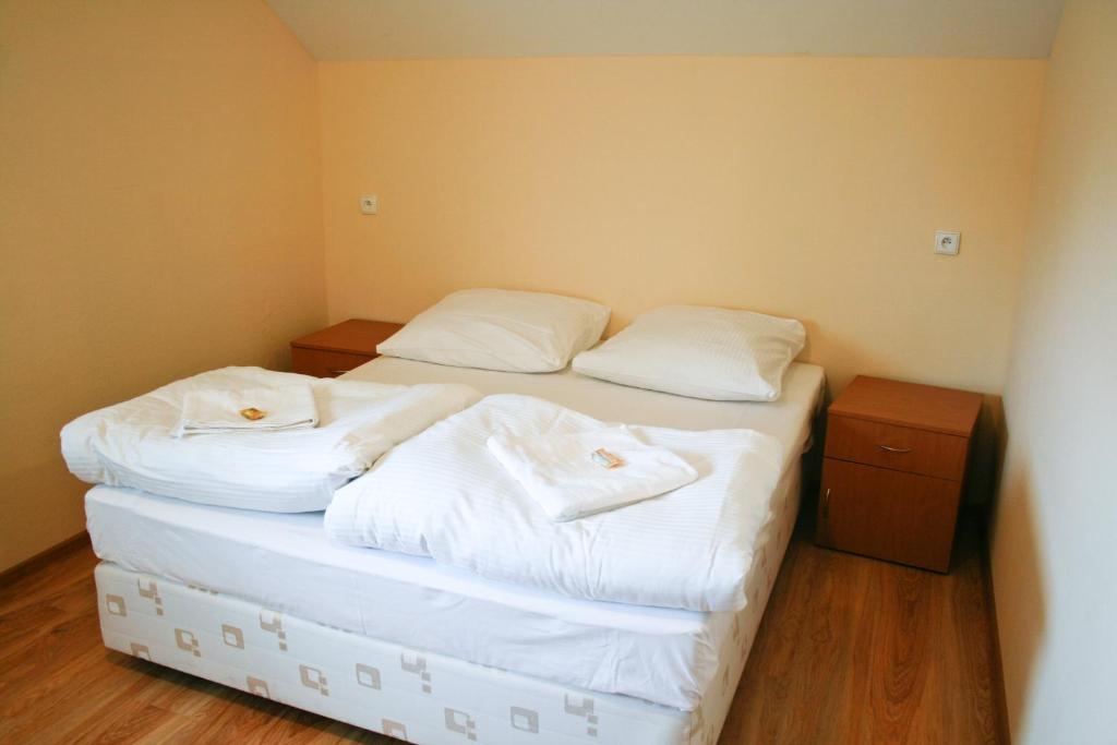 2 camas en una habitación con sábanas blancas y toallas en Hotel 7, en Szczecin
