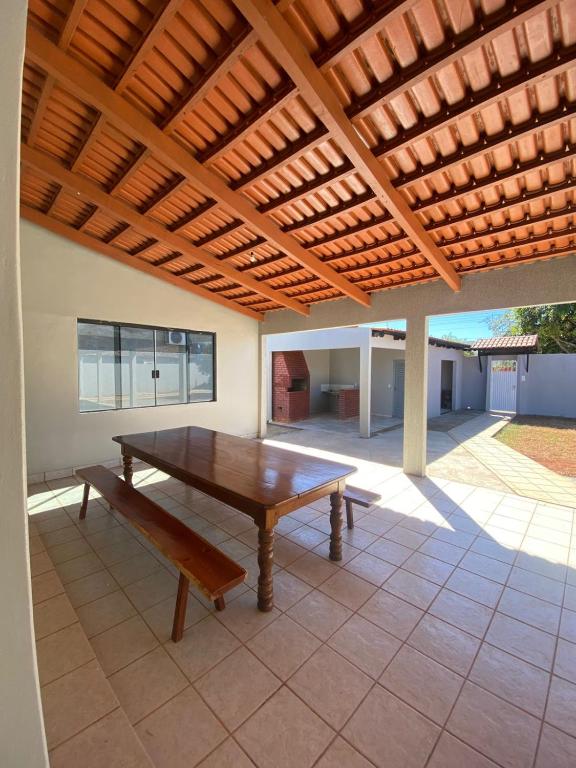 a wooden table and a bench under a wooden pergola at Casa Jabuticabeira in Manhã