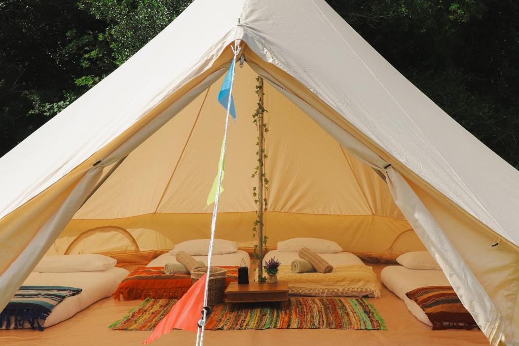 a white tent with a bunch of pillows in it at Festival Glamping At The Drum - Glamping Village in Edinburgh