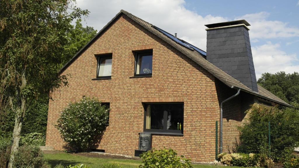 a brick house with a chimney on top of it at Villa Daheim in Bad Rothenfelde