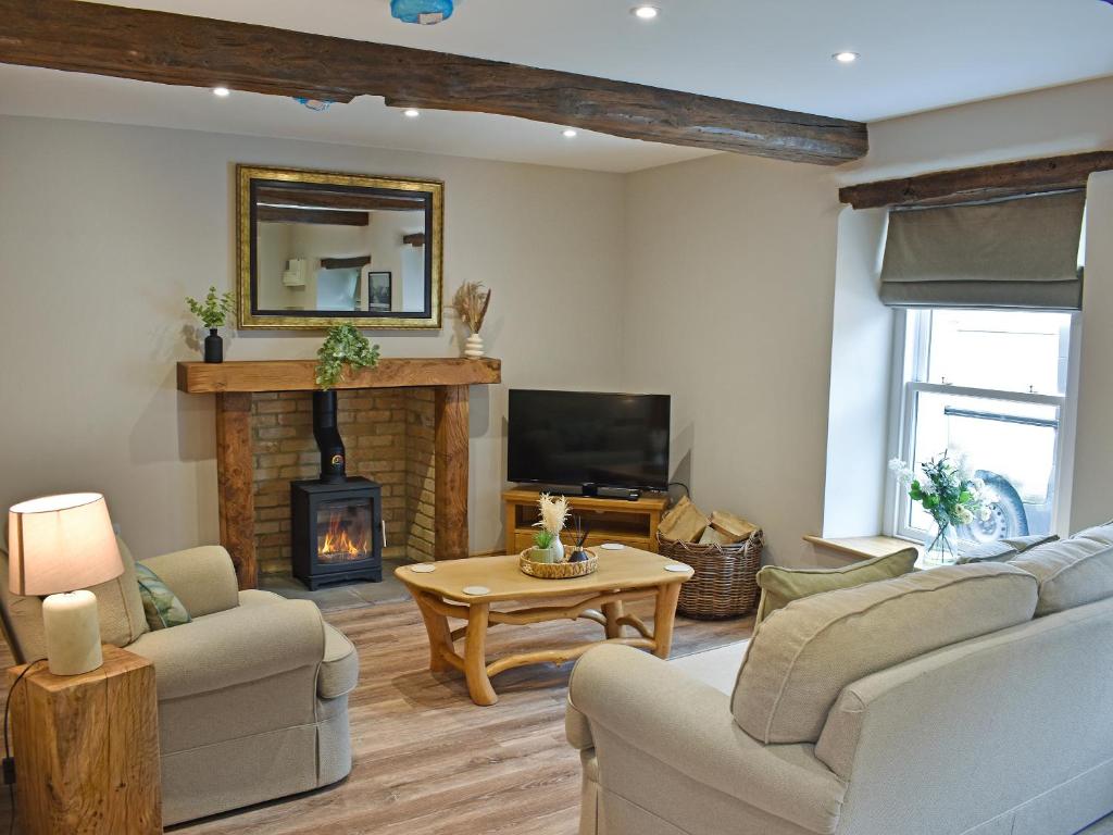 a living room with a couch and a fireplace at 14 Doomgate House - Uk45055 in Appleby