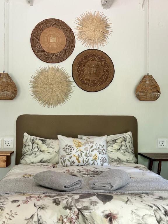 a bedroom with a bed with hats on the wall at Meander Stay Clarens in Clarens