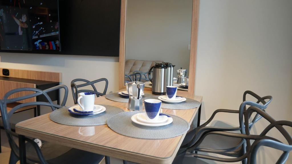 a wooden table with chairs and cups on top of it at 098house in São Luís
