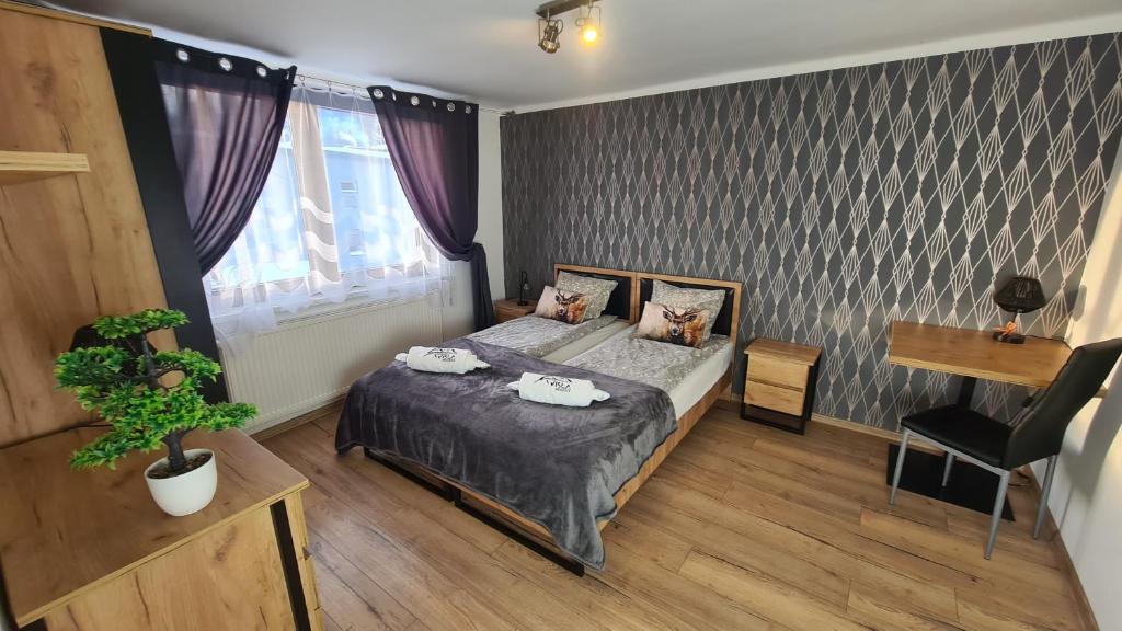 a bedroom with a bed and a table and a plant at Wisła Apartament Gór-SKI z jacuzzi in Wisła