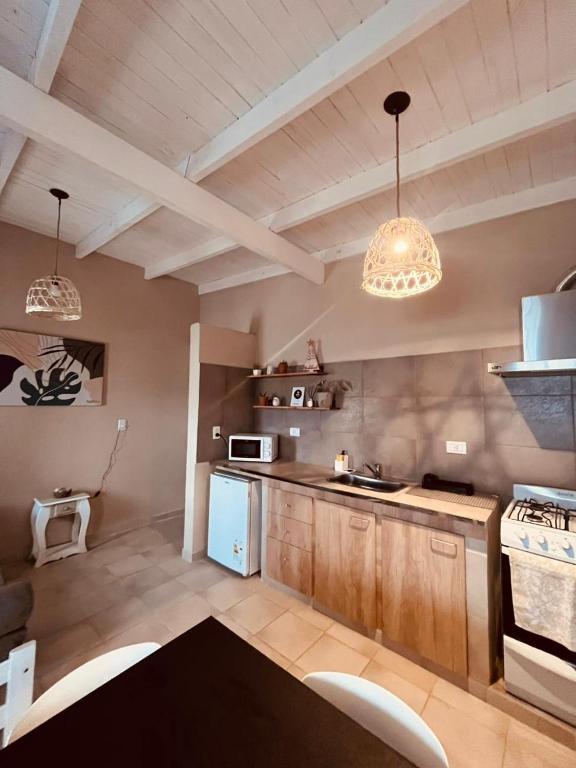 a kitchen with two chandeliers and a blue refrigerator at Apart Los Laureles Dpto 2 in Villa Regina