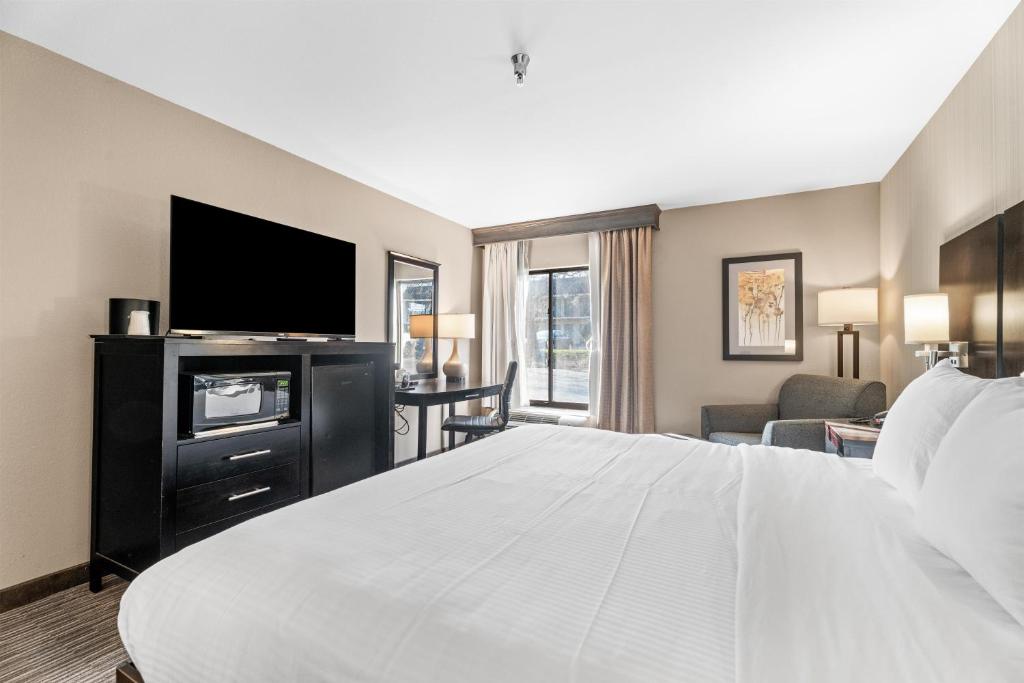 a hotel room with a large bed and a flat screen tv at Best Western Courtview Hotel in Springfield