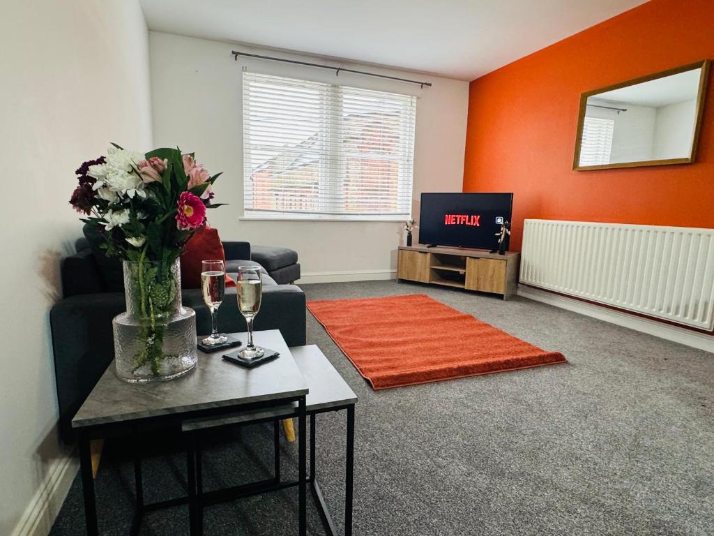 a living room with a vase of flowers and a tv at Curwen Apartment - 2 Bedrooms - Sleeps 6 in Workington