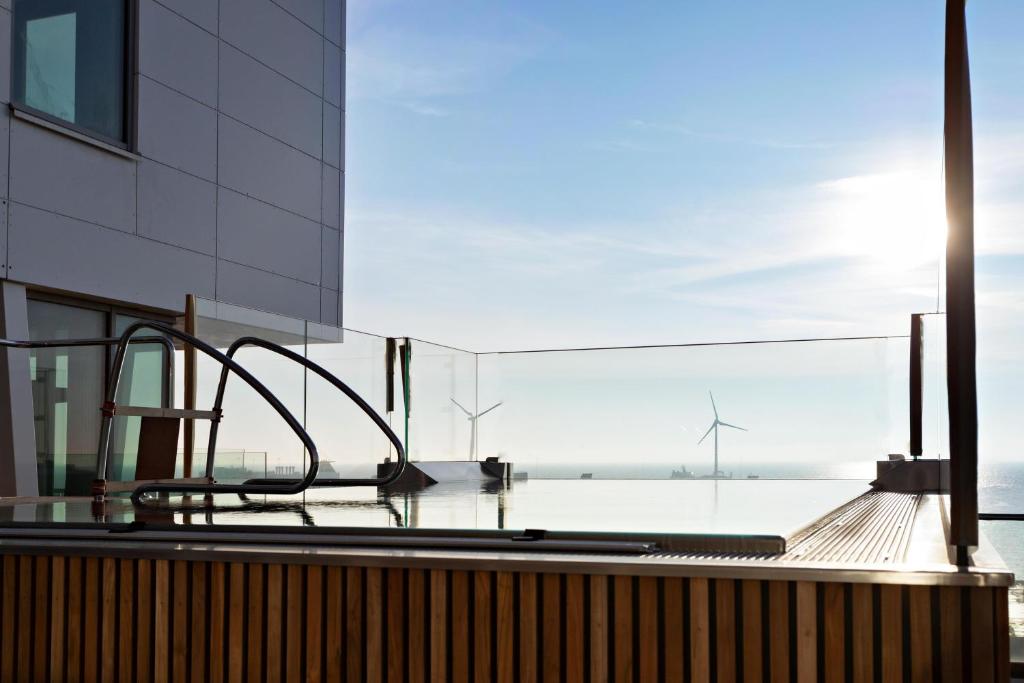 a view from the balcony of a building with a view of a wind turbine at Willow, WorldHotels Crafted in Trelleborg