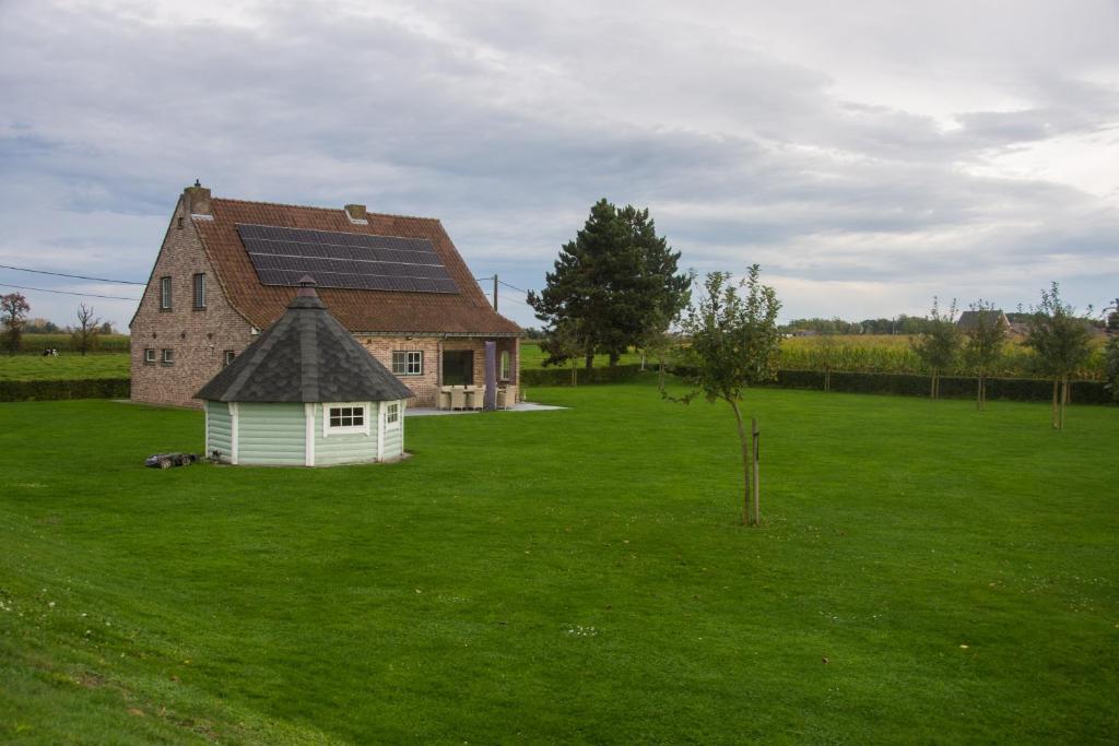 a house with solar panels on top of a green field at 'Op de Borgt' met Finse Grill Kota in Wellen