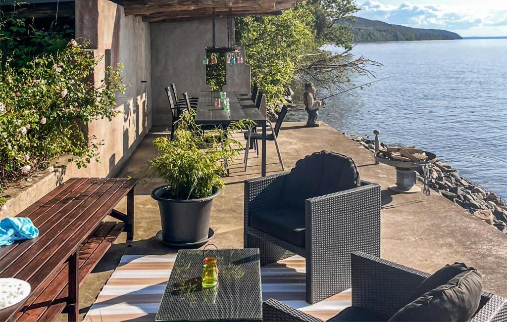a patio with tables and chairs next to the water at Nice Home In Gränna With House Sea View in Gränna