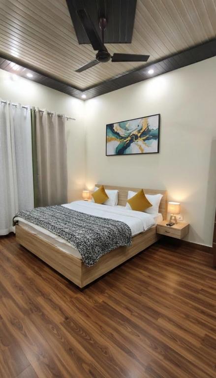 a bedroom with a large bed and wooden floors at Amigo's Hotel and Restaurant in Nandaprayāg