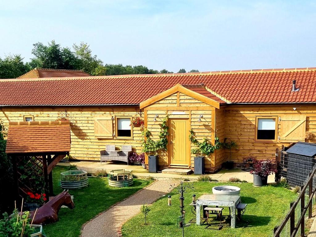a small wooden house with a table and a fence at Mac Shack Cottage - Uk32376 in Ashen