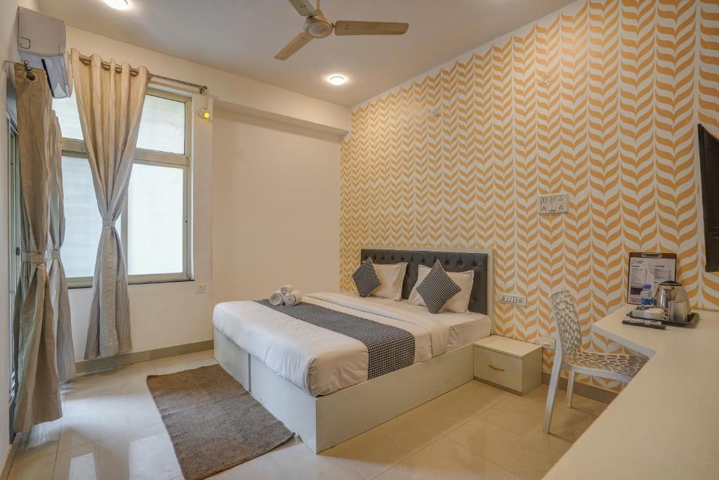 a bedroom with a bed and a desk and a window at Urban Villa ,Baner in Pune