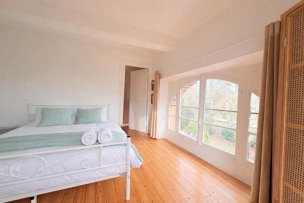 a bedroom with a bed and a large window at L'Authentic - Appartement spacieux in Villeneuve-sur-Yonne