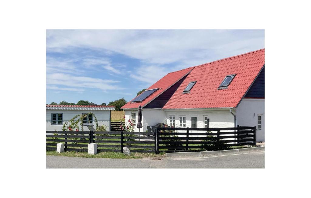 a house with a red roof and a fence at Elsebeth Fahlgren Ellegaard in Ærøskøbing