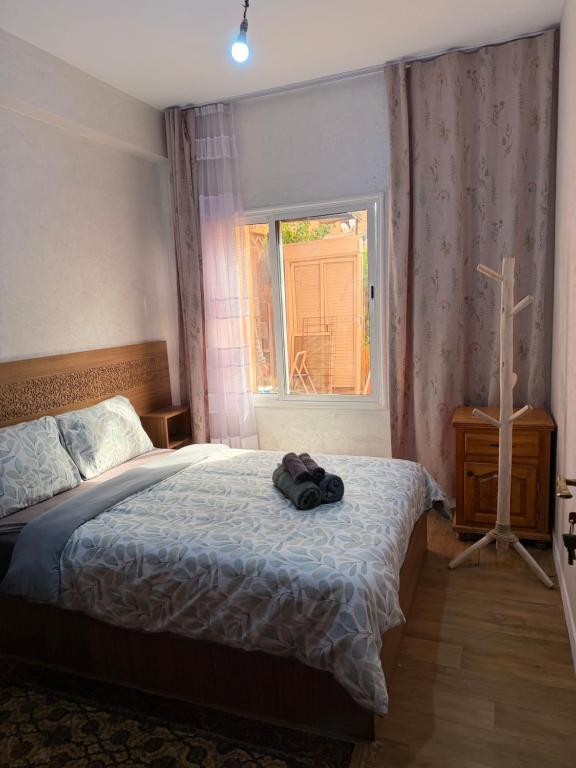 a bedroom with a bed and a cross on a window at Julie Airport Boarding Apartment in Marrakesh