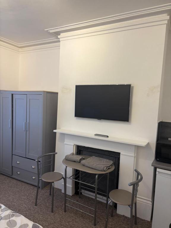 a room with a fireplace with a flat screen tv above it at Palace in Crystal Palace