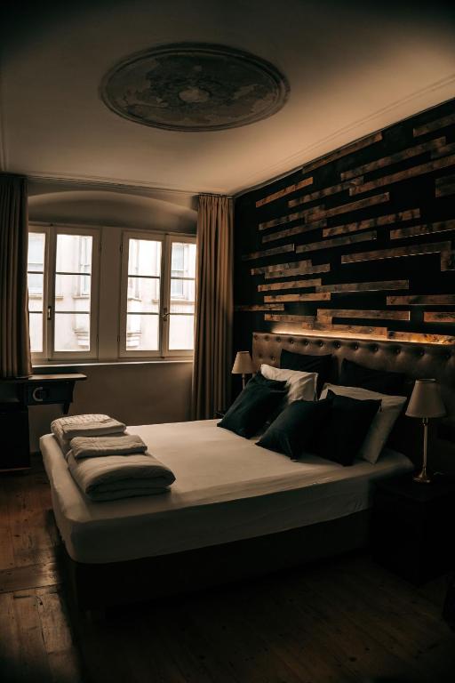 a bedroom with a large bed with pillows on it at Sir Thomas Bed Central in Bolzano