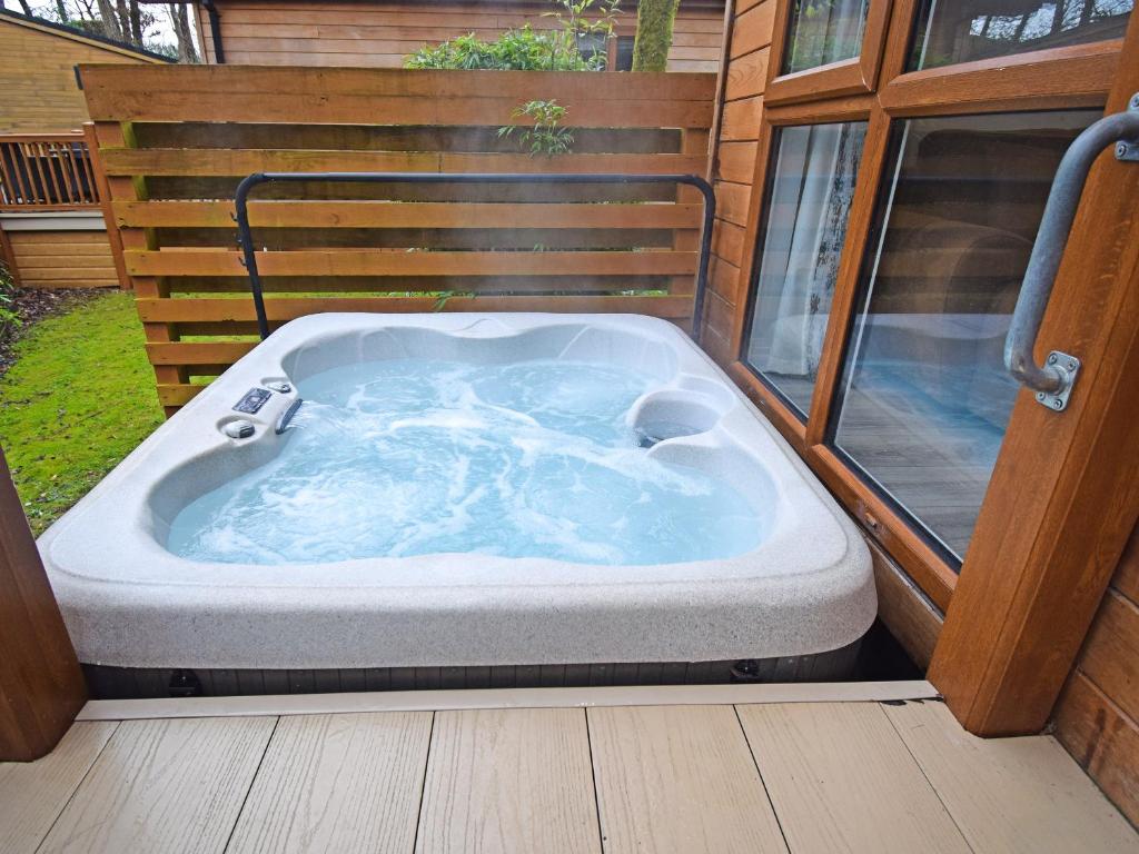 a jacuzzi tub sitting on a deck at Bluebird Lodge 2 - Uk50932 in High Nibthwaite