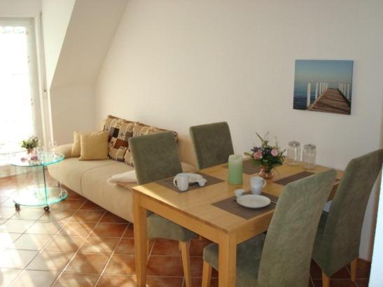 a living room with a table and a couch at Küstenliebe in Kirchdorf