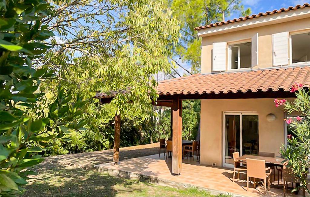 a house with a patio with a table and chairs at Maison 1 in Montauroux