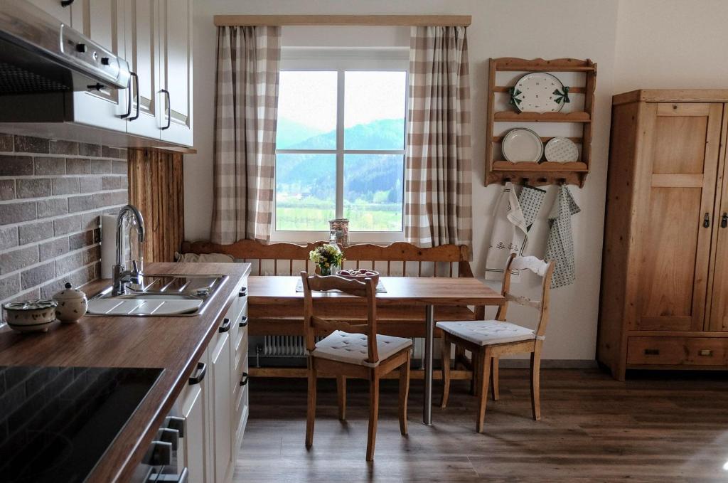 a kitchen with a table and chairs and a window at Apartmenthaus Eisenstraße in Lunz am See