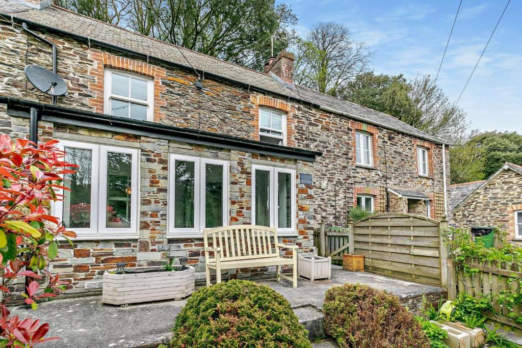 a brick house with a bench in front of it at 2 Bed in Wadebridge oc-r27444 in Little Petherick